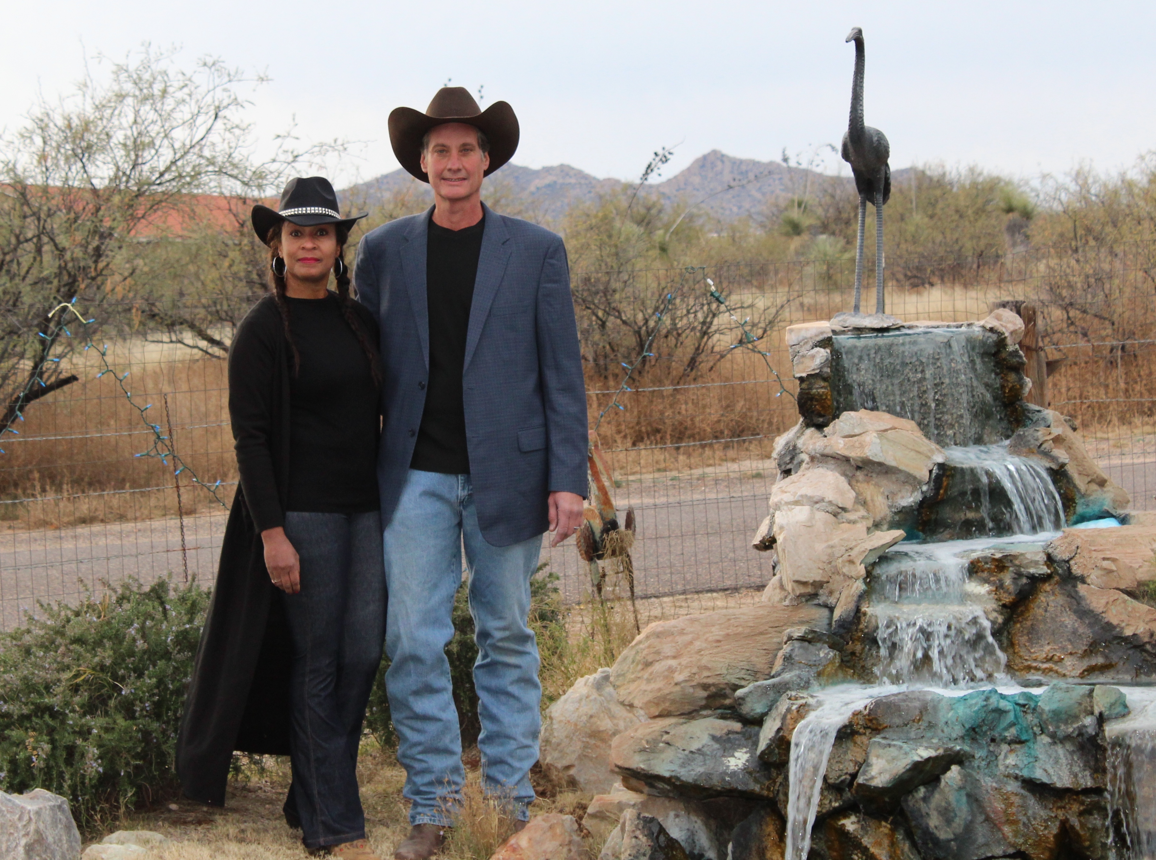 A man and woman standing in front of an ostrich statue.